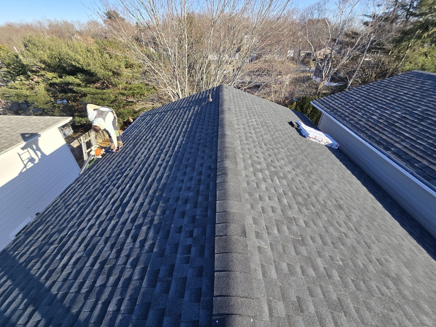 A finished dark architectural shingle roof seen along the ridge